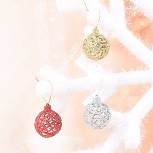 Close-up of hollow glitter Christmas ornaments hanging on snowy branches