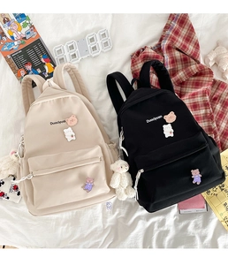Kawaii school backpacks in beige and black with cute cartoon bear pins and charms