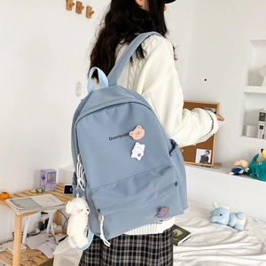 Detail of light blue nylon backpack with cute bear pendant and Duociyuan logo