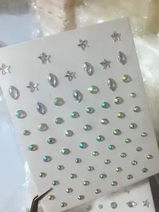 Detail of aurora crystal stickers in star and marquise shapes with metal tweezers