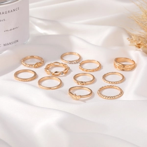 Set of 11 vintage gold alloy rings with star, moon, and butterfly motifs on silk cloth