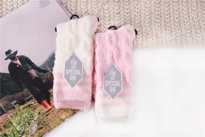 Detail of pink and white striped coral fleece socks with special label on a cozy background