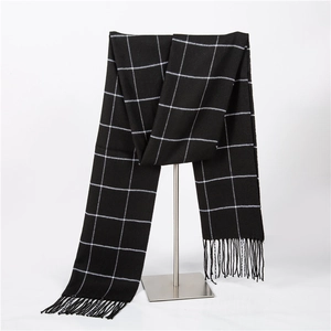 Close-up of black and white checkered scarf featuring soft knit texture and fringe detail