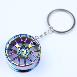 Detail shot of rainbow electroplated metal car wheel rim keychain with a shiny finish