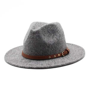 Detail view of grey fedora texture with brown leather band and gold buckle