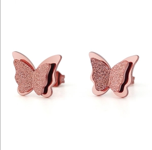 Detail of rose gold butterfly earrings with frosted texture and double-layered 3D design