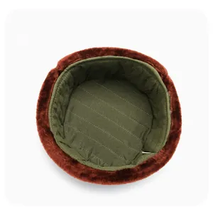 Macro view of army green quilted lining and brown plush faux fur trim on winter hat