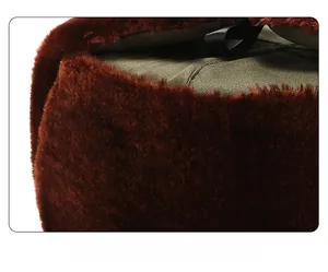 Close-up of thick brown faux fur lining and olive green fabric on winter trapper hat