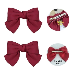 Detail of wine red bow hair clip showing spring clip and duckbill clip backings