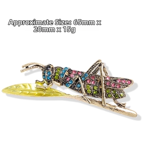 Detail view of insect grasshopper brooch with colorful rhinestones on a yellow leaf