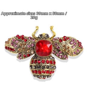 Detailed view of luxury bee brooch with red rhinestones and vintage gold alloy finish