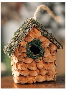 Detailaufnahme der Vogelhaus-Deko aus Kiefernzapfen mit Moos und Juteseil-Aufhänger