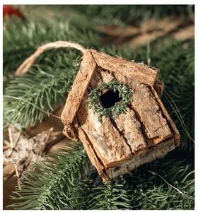 Detail eines rustikalen Rinden-Weihnachtshauses mit Kranz und Hanfseil zum Aufhängen