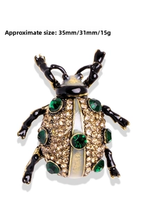 Macro shot of beetle brooch featuring sparkling rhinestones and green crystal accents