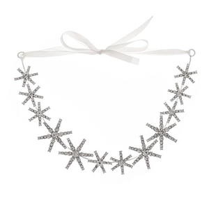 Detail of silver bridal headband featuring snowflake crystal clusters and white ribbon tie