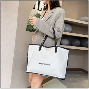Detail of the white tote bag with black trim and elegant printed lettering design