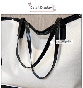 Detail shot of sturdy canvas fabric and black shoulder strap stitching on the tote bag