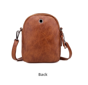 Detail view of the back of a vintage brown crossbody bag with metal earphone port