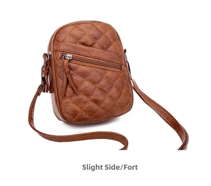 Detail view of brown quilted crossbody bag with yellow stitching and double zip design