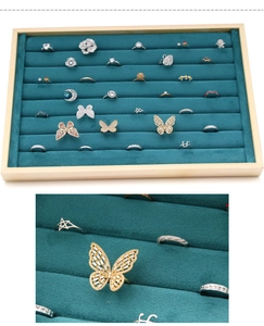Macro detail of dark green velvet jewelry tray showing multiple ring display slots