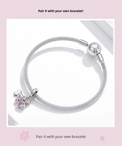 Detail of pink heart paw print charm on woven mesh bracelet with Forever Love engraving