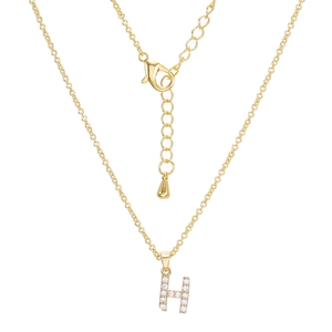 Detailed macro of golden necklace with sparkling rhinestone paved letter H pendant