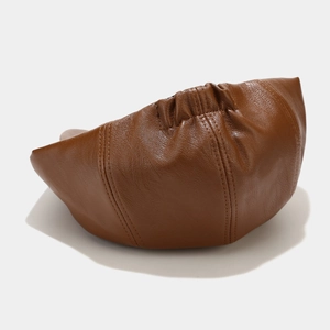Close-up of brown leather newsboy cap showing stitching and back elastic detail