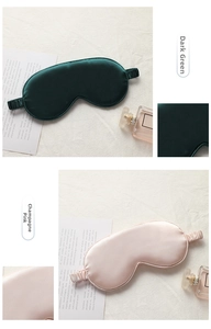 Detail view of silk satin eye masks in dark green and champagne pink with elastic straps