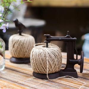Vintage cast iron twine holder set with bird and sewing machine design for garden decor