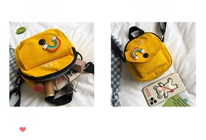 Detail showing the internal storage capacity and size comparison of the yellow canvas bag
