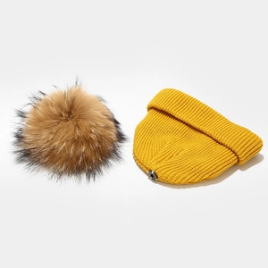 Detail of yellow ribbed knit baby hat with snap-on brown fur pom-pom attachment