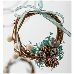 Detail of Christmas wreath with light blue bow, white berries, and natural pine cones