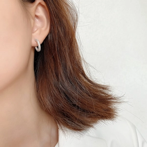 Close-up of minimalist silver hoop earrings with shimmering pavé set cubic zirconia