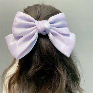 Detail of a large purple organza bow hair clip with a pearlescent laser silk finish