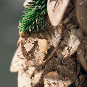 Rustic wooden Christmas tree ornament with birch bark texture and snowy pine needles