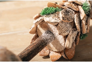 Macro detail of wooden Christmas tree slices with frosted pine needles and artificial snow