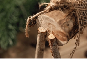 Détail macro du grain de bois naturel et du nœud en corde sur déco de Noël en bois