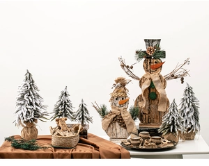 Rustic wooden snowman set with burlap scarves and frosted mini pine trees on brown silk