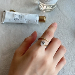 Close-up of a gold adjustable silver ring with a pear-cut zircon on a model hand