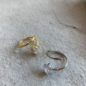 Macro shot of minimalist silver and gold heart rings with spiral wrap design detail