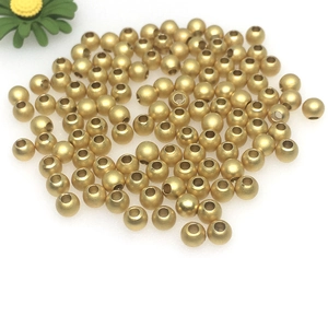 Bulk 14k gold-filled polished metal spacer beads for DIY jewelry making on white background