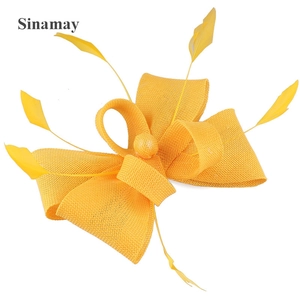 Detail of yellow Sinamay mesh bow fascinator with elegant decorative feathers
