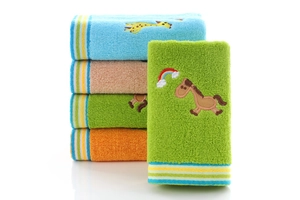 Detail of colorful cotton children towels with embroidered animal patterns and striped edges