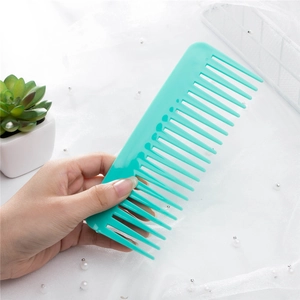Cyan wide-tooth plastic hair comb for detangling being held against a minimalist background