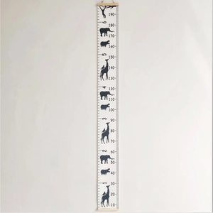 Detail of wooden canvas height chart with black animal silhouettes for kids room decor