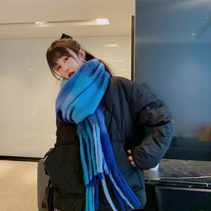 Close-up of blue gradient plaid scarf with fringes on a model wearing black down jacket