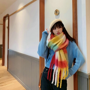 Detail of colorful rainbow plaid scarf with thick knit texture and fringe tassels