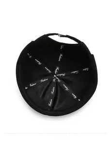 Detail view of the black cotton docker hat with branded inner tape and metal buckle