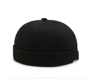 Detail view of black brimless docker cap showing cotton twill fabric texture and stitching