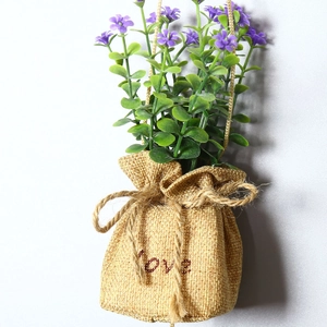 Artificial hanging plant with purple flowers in a burlap Love bag for home wall decor